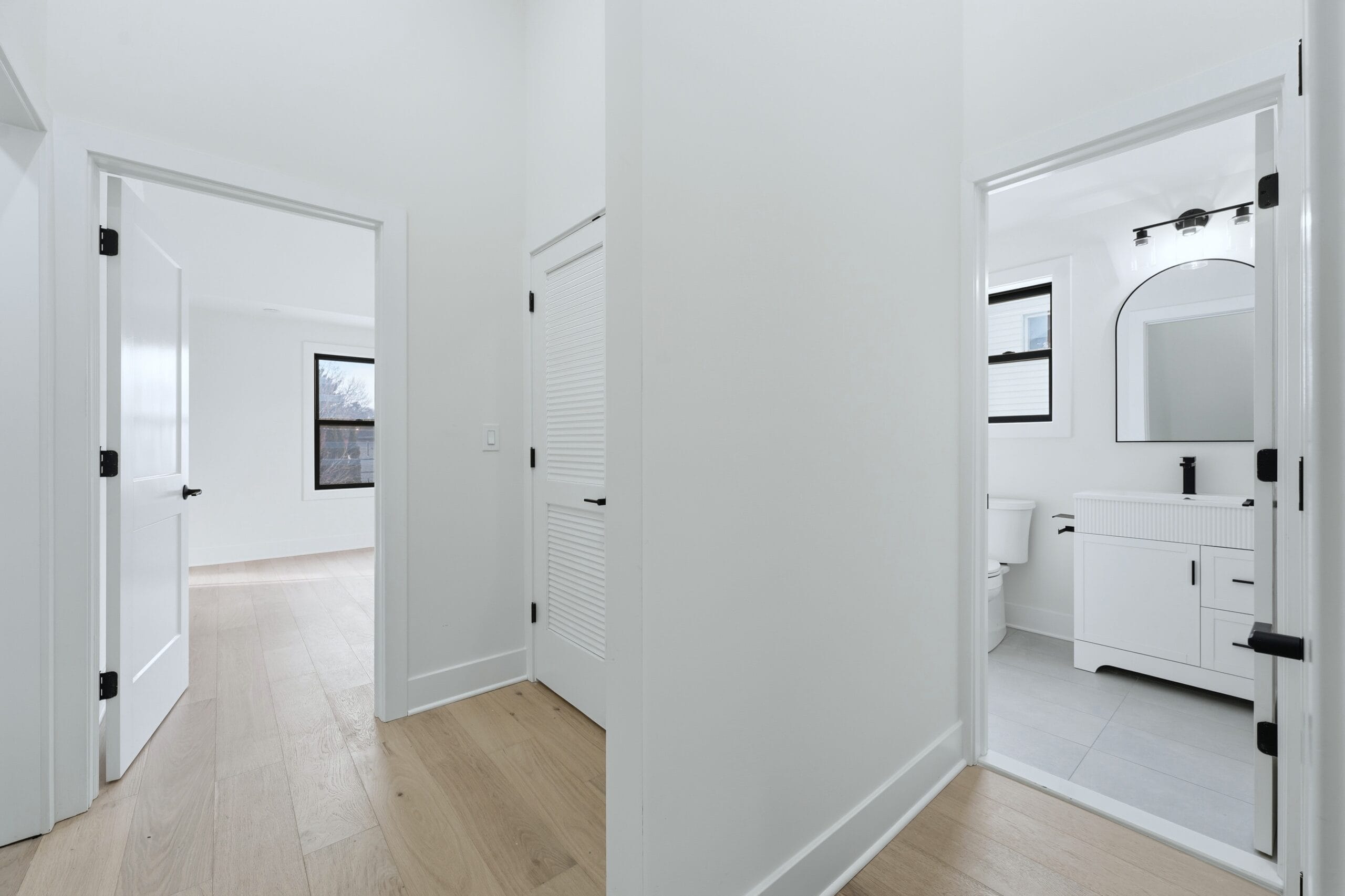 Upstairs hallway with white oak floors leading to the bedrooms and a bright en-suite bathroom