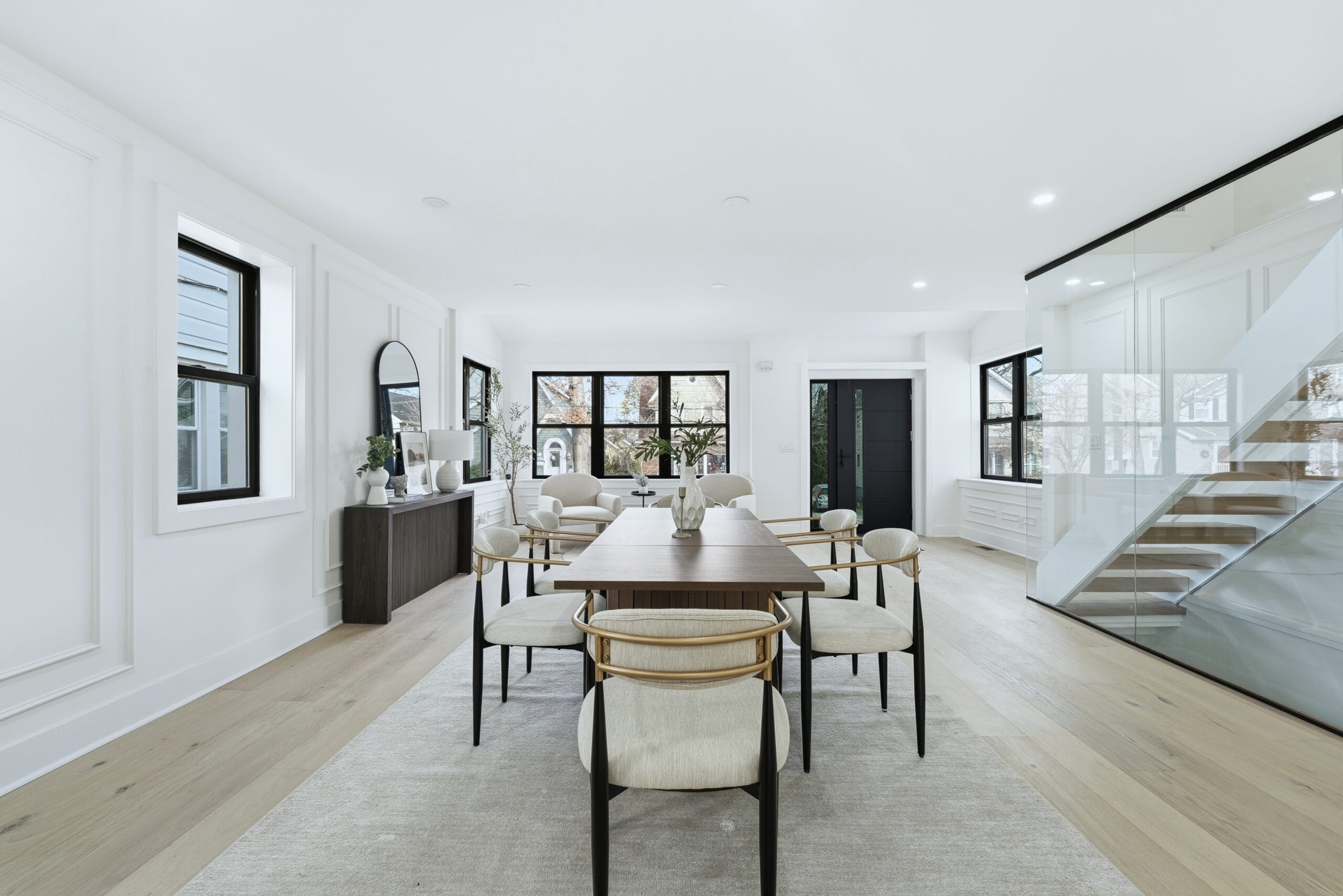 Open dining area with a walnut table and a glass-railed staircase at 820 Elm Avenue