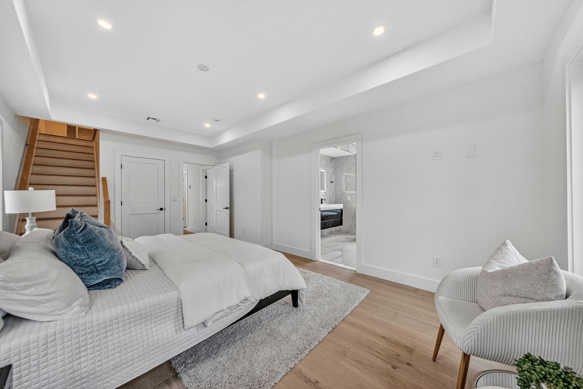 Primary bedroom with a tray ceiling opening onto the staircase landing