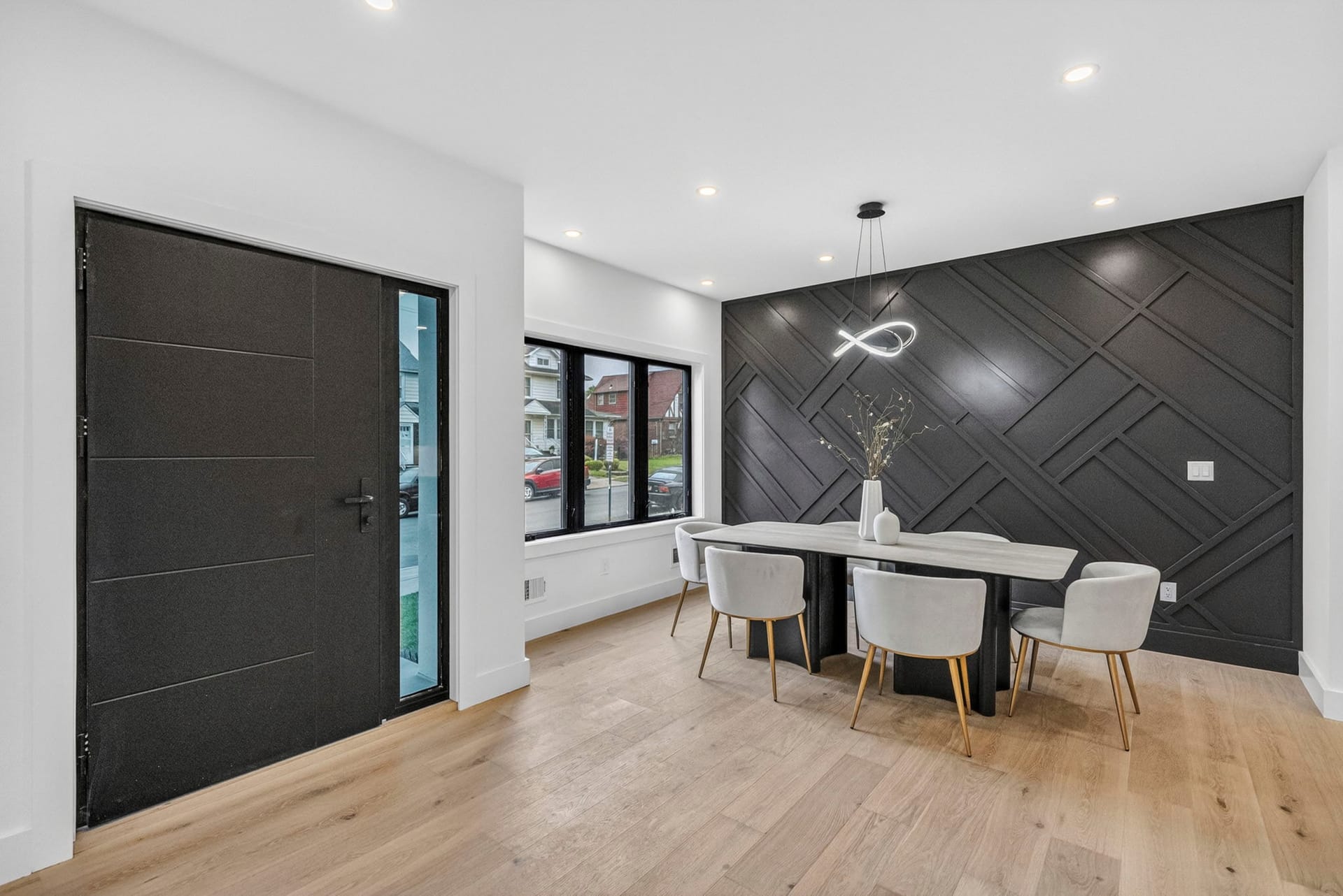 Entry foyer with a geometric dark accent wall beside the dining area