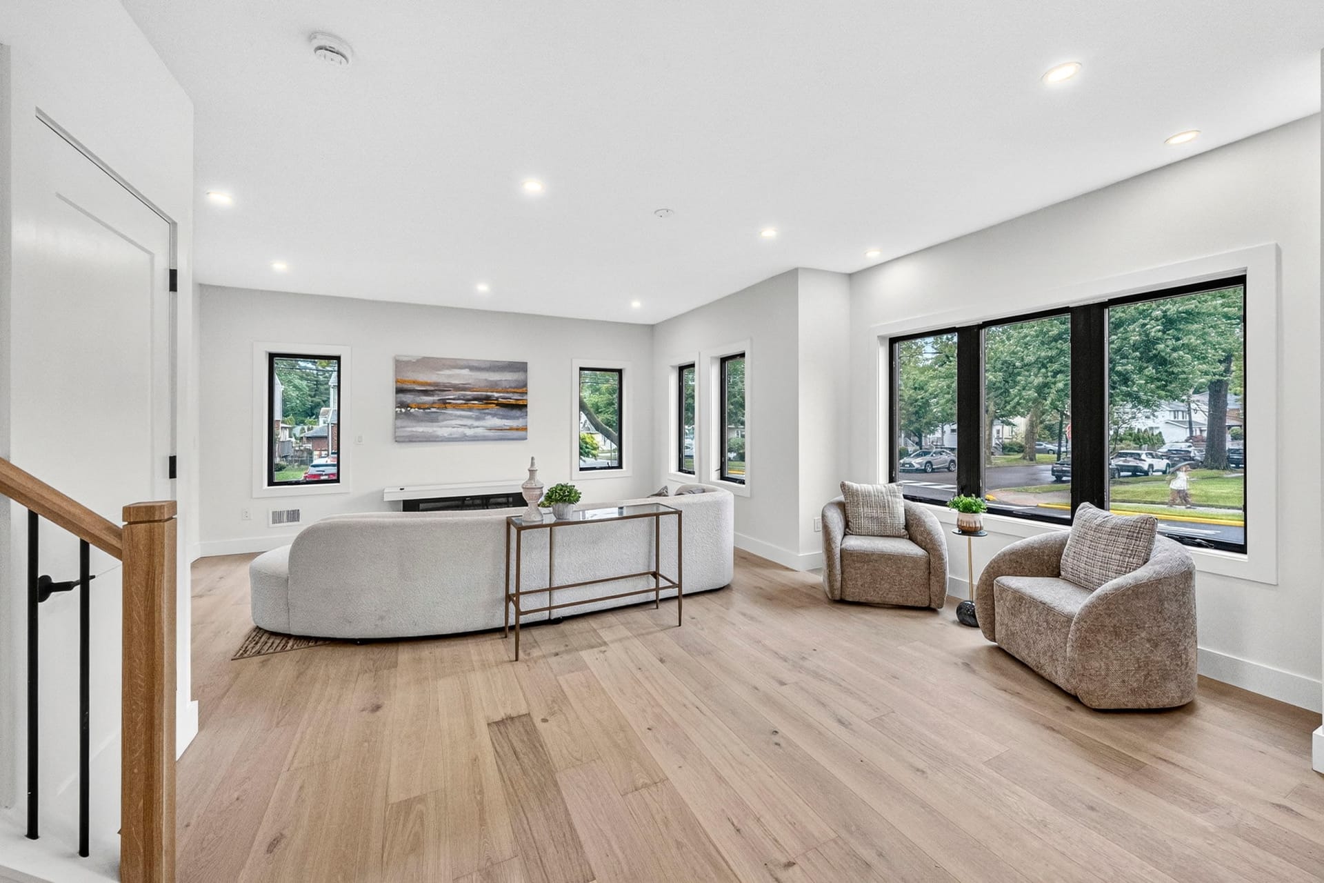 Living room with a curved sofa, accent chairs, and large windows