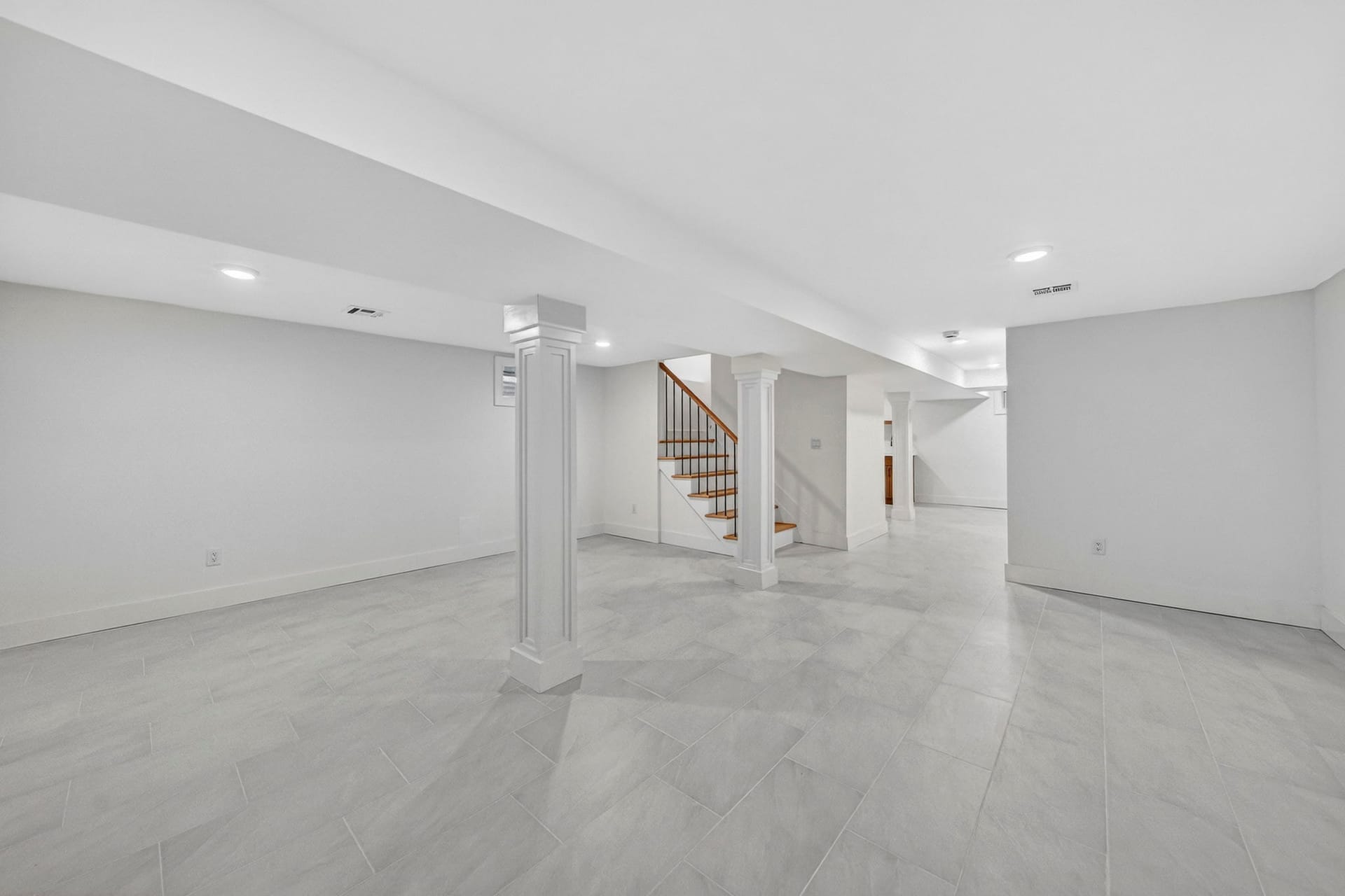 Basement recreation room with the staircase and columned entry