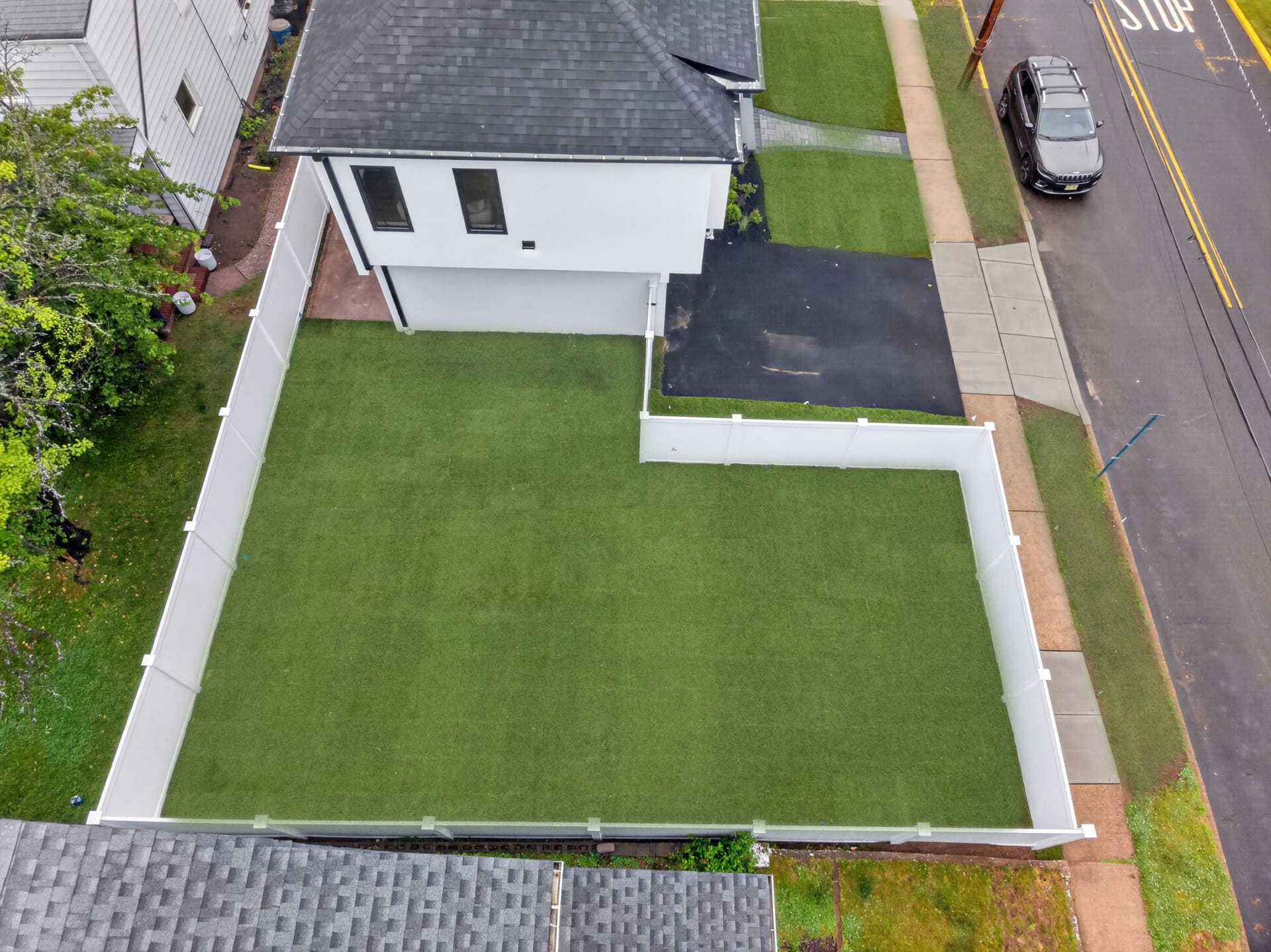 Aerial view of the fenced backyard with artificial turf