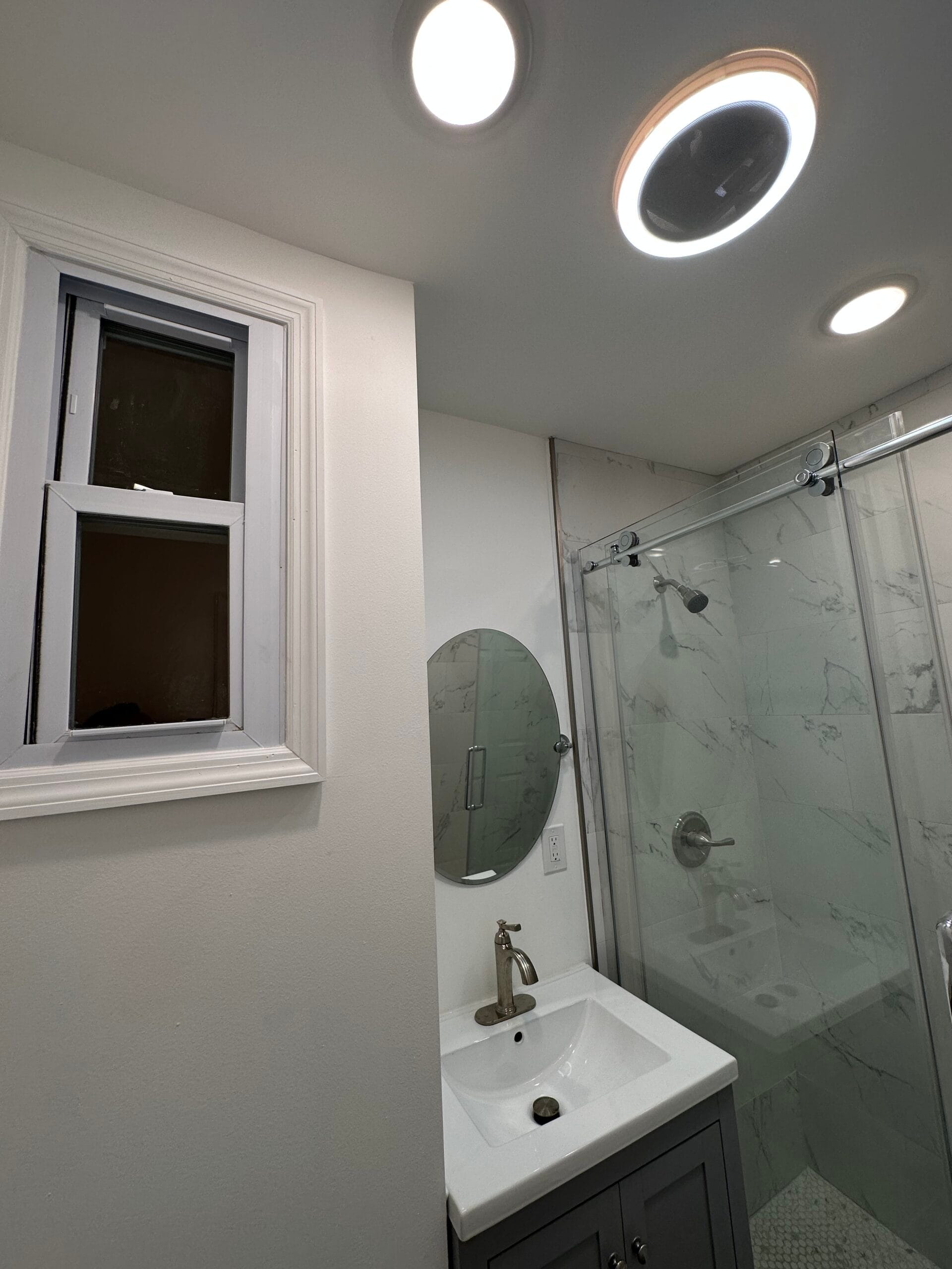 Clifton bathroom remodel with marble-look tile and a glass shower enclosure